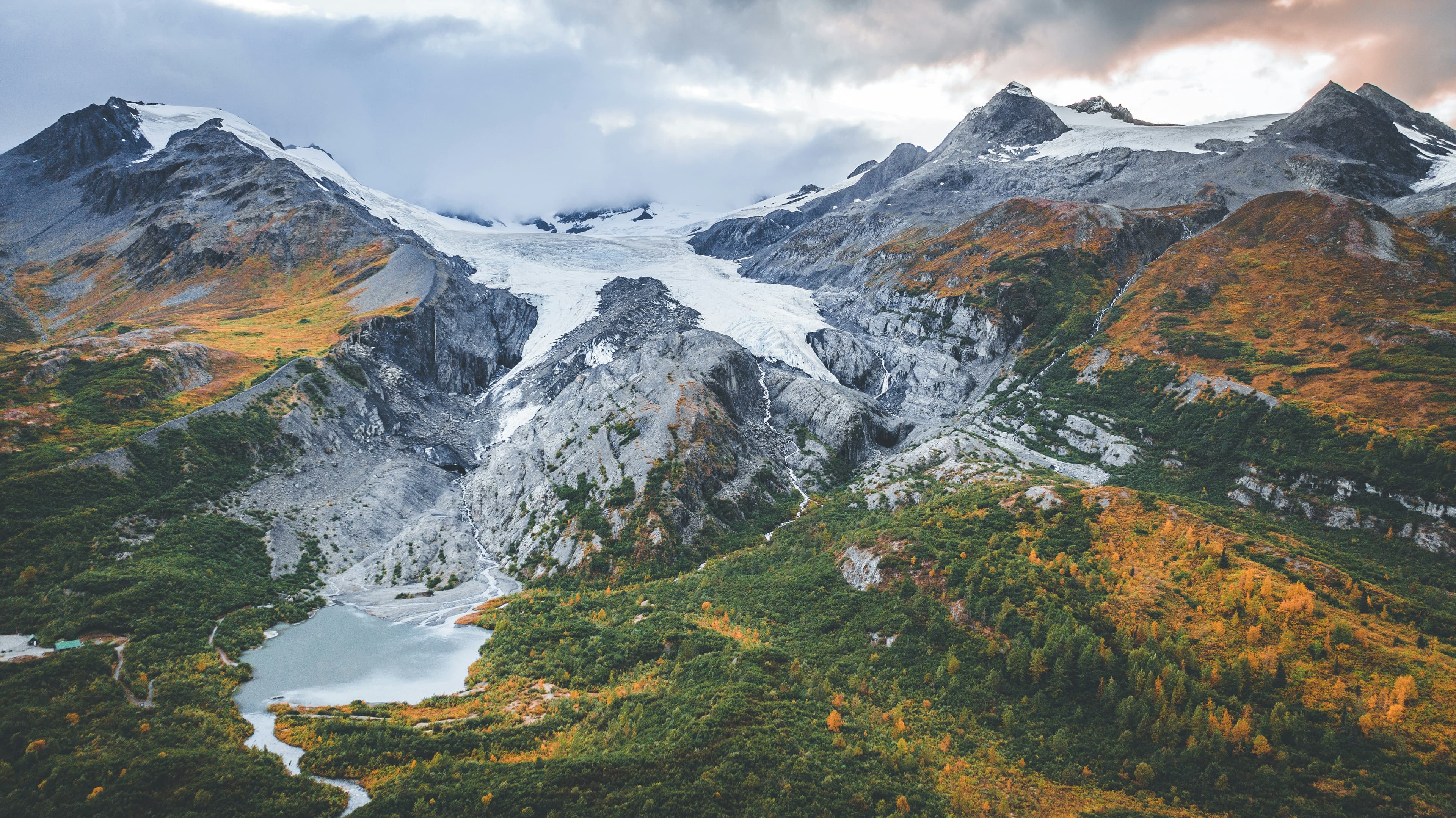 Aerial view of an Alaskan glacier, alpine lake, and autumn tundra